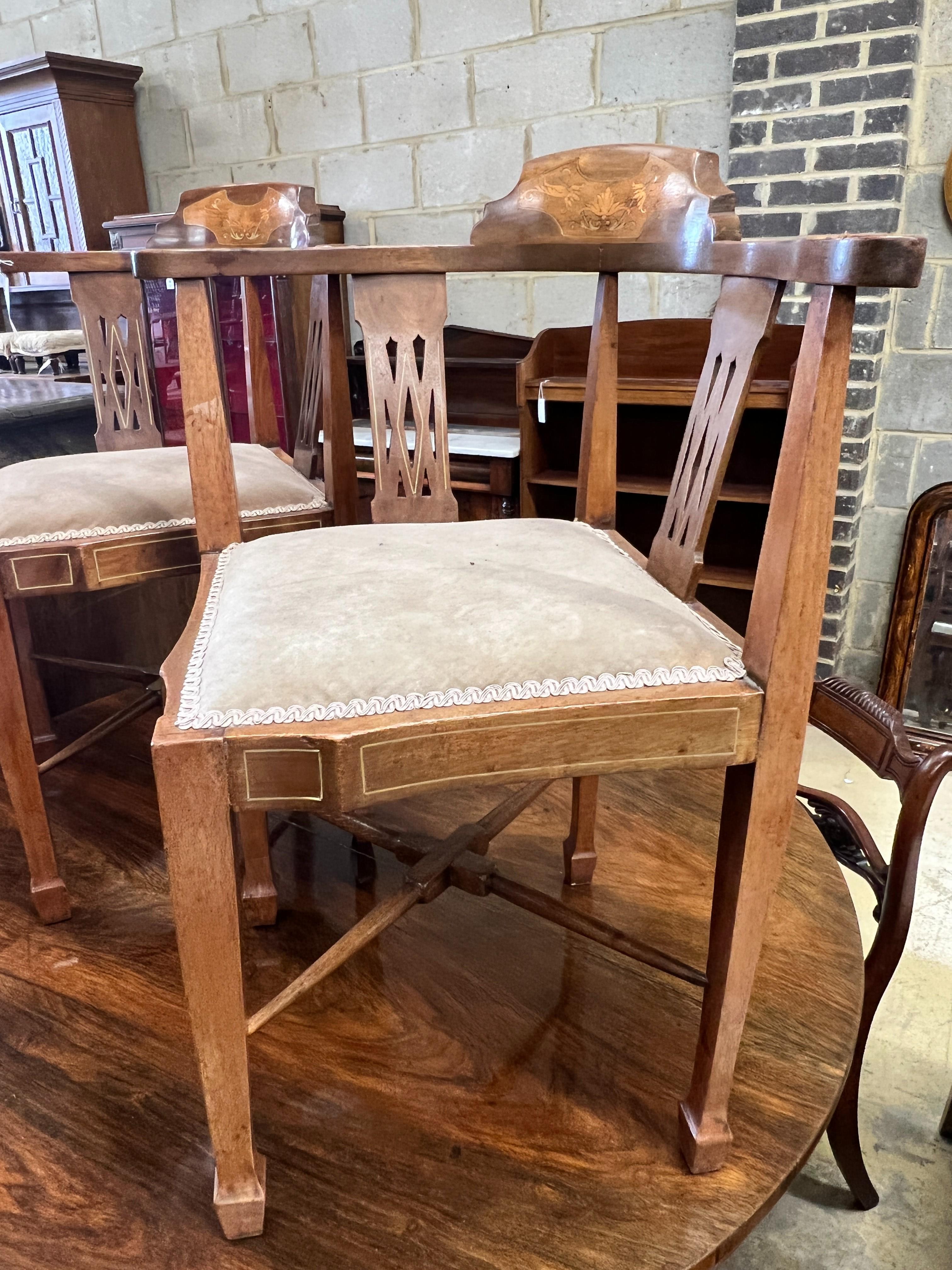 A pair of Edwardian inlaid mahogany corner elbow chairs